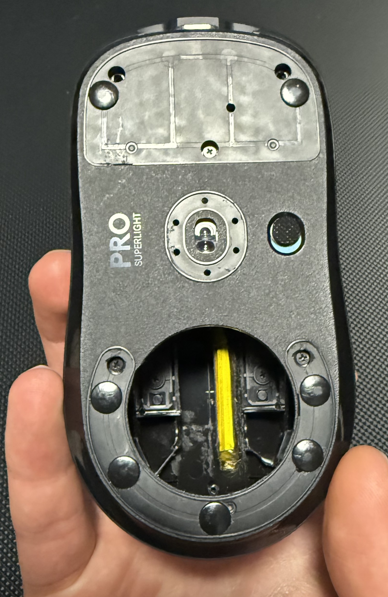 bottom side of superlight mouse with skates and cut out bottom for weight